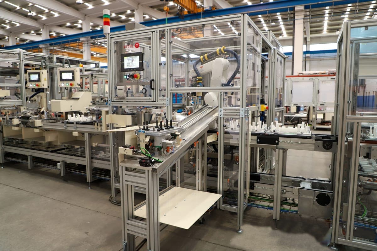 LÍNEA MONTAJE ELECTRÓNICA MT9 — Línea FMS con 5 robots para montaje y despaletizado con visión artificial y 4 equipos de collado automático.